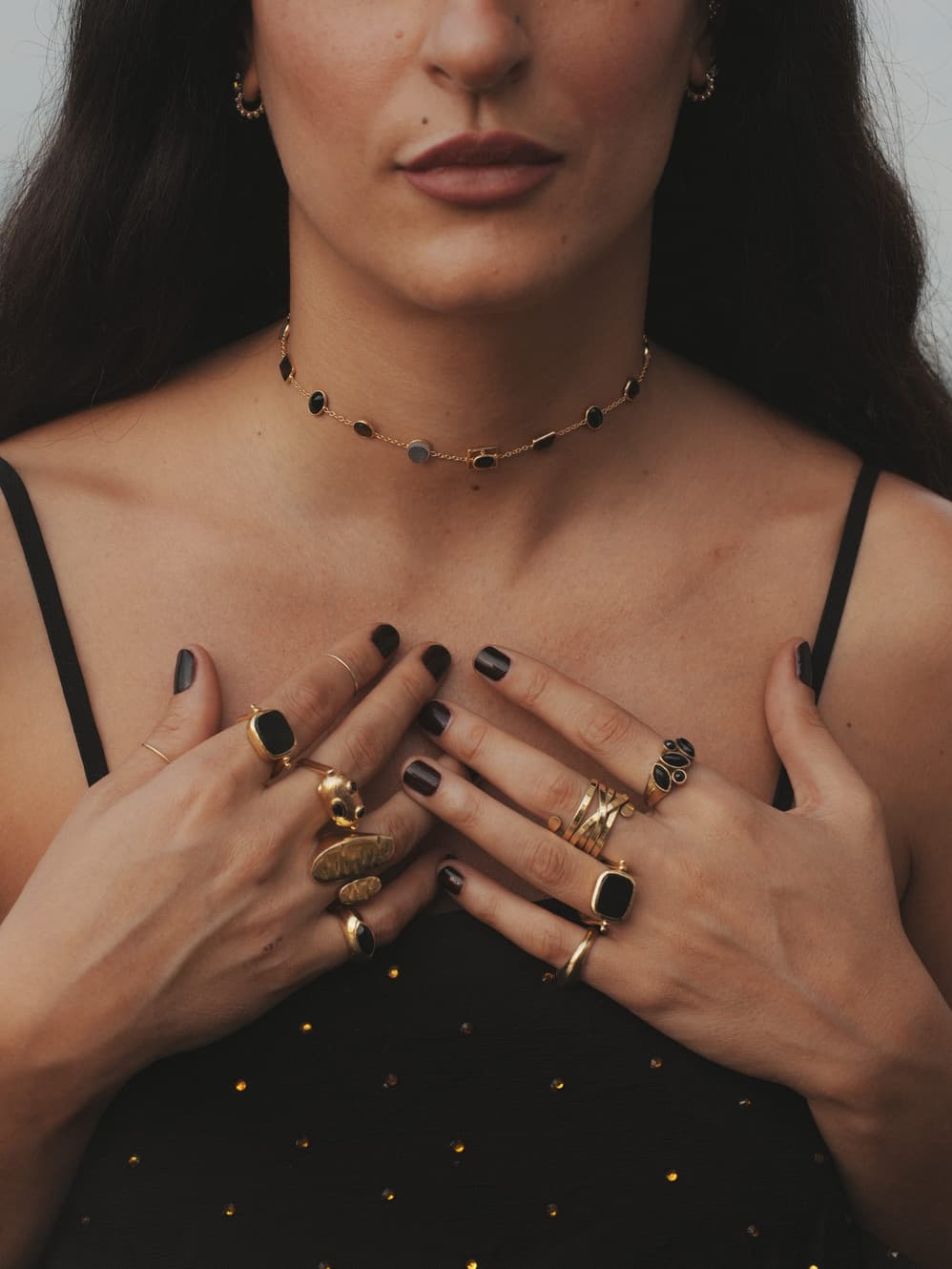 Collana e anelli Sbrilluccica indossati su un abito nero